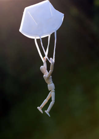 Wooden figure flying with protective mask. virus or  virus infection concept.の写真素材