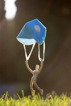 Wooden figure flying with protective mask.  virus infection concept.の写真素材