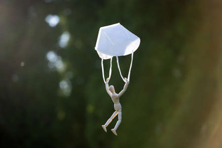 Wooden figure flying with protective mask.virus infection concept.の写真素材