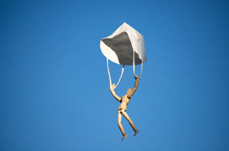 Wooden figure flying with protective mask on blue sky.  virus infection concept.の写真素材