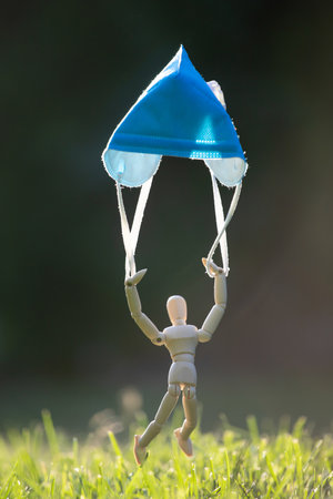 Wooden figure flying with protective mask.の写真素材