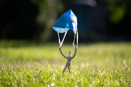 Wooden figure flying with protective mask. virus infection concept.の写真素材
