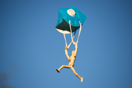 Wooden figure flying with protective mask on blue sky.の写真素材