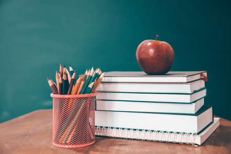 Back to School Concept. Apple, accessories and books against chalkboard.の写真素材