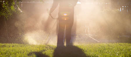 Mowing the grass with a lawn mower. Garden work concept background.の写真素材