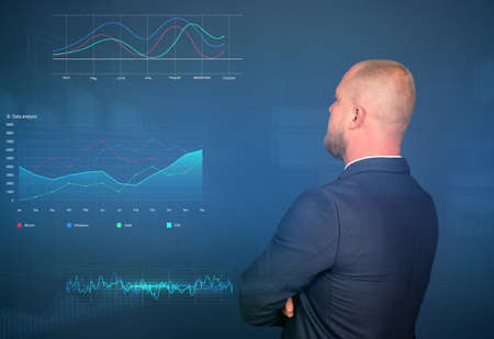 Businessman analysing stock market indicators or financial data and charts for best investment...
