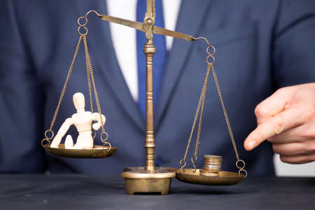 Conceptual financial and business photo of scale with people on one pan and money on the other...