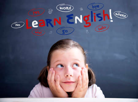 Language education, learn english concept. Little girl with eyeglasses looking at Learn english text...
