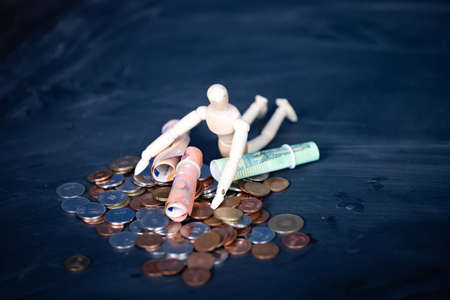 Wooden man lying on a stack of money. Business, financial concept.の写真素材