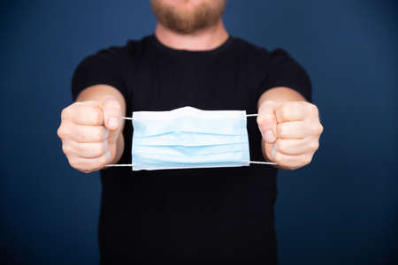 Medical mask as handcuffs on man hands.の写真素材