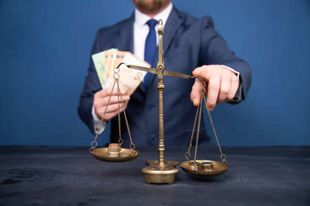 Concept of earning balance with businessman that weighs the moneyの写真素材