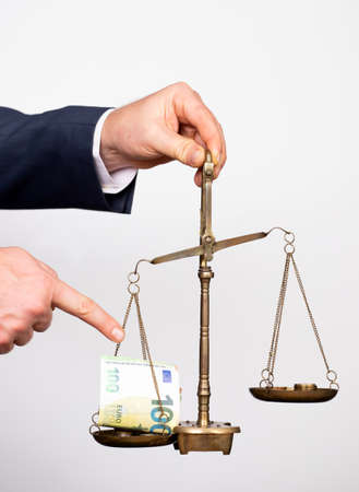Business man holding balance scale with money. Money management, time value of money and saving money concept.の写真素材