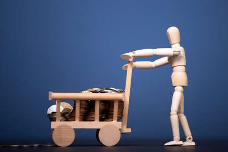 Wooden man carrying money. Business and finance concept