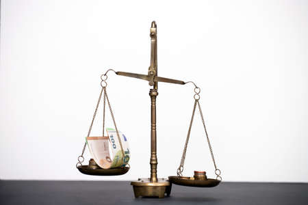 Balance scale with coin stacks. Money management, time value of money and saving money concept.の写真素材