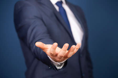 Businessman in suit holding something imaginary on palms of his hands. Business and advertisement...
