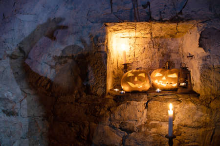 Jack O' Lantern glowing in old cellar, ghost silhouette on the wall.Creepy Halloween backgroundの写真素材