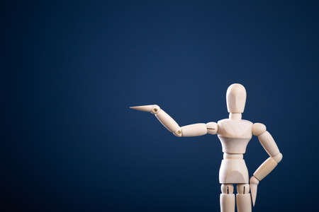 Wooden figure pointing at empty space, showing product. Advertising conceptの写真素材