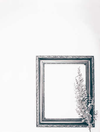 Minimalistic Christmas card mockup with silver branch and old frame.の写真素材