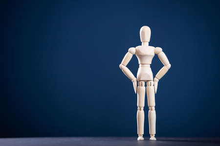 Wooden figure on blue background with copy space. Advertising conceptの写真素材