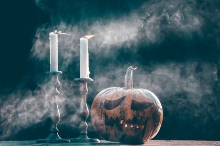 Jack O' Lanterns glowing in smoky fantasy night with candles. Halloween backgroundの写真素材