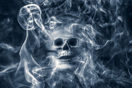 Scary skull emerging from a cloud of smoke . Halloween background.の写真素材