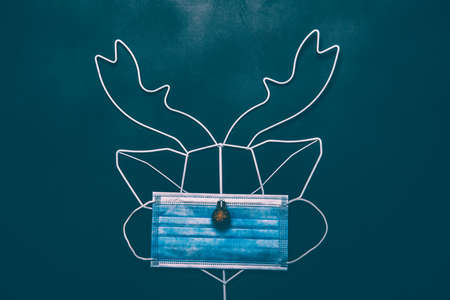 Celebrating Christmas during coronavirus pandemic. Reindeer made of face mask and decorationsの写真素材