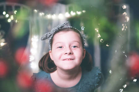 Little girl with near Christmas tree on Christmas eve at home. Christmas, New Year, time for...