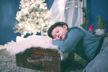 Little girl with near Christmas tree on Christmas eve at home. Christmas, New Year, time for celebration conceptの写真素材