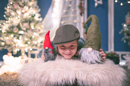 Little girl with near Christmas tree on Christmas eve at home. Christmas, New Year, time for celebration conceptの写真素材