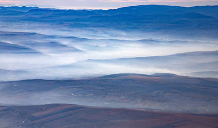 Aerial, airplane view of mountains in the sunrise