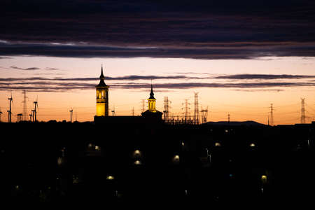 Silhouette of aligned windmills for renowable electric production at sunset in Spain