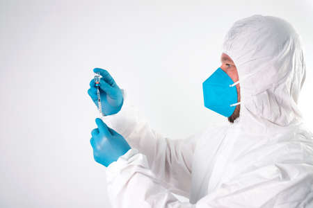 Vaccination concept. Doctor's hand in blue gloves hold medicine vaccine vial bottle and syringe.の写真素材