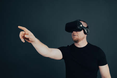 Metaverse digital cyber world technology. Man with VR glasses using AR augmented reality entertainment. NFT game, futuristic lifestyle.の写真素材