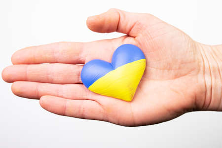Heart shaped flag of Ukraine in female hands. The concept of solidarity with the citizens of Ukraine.の写真素材