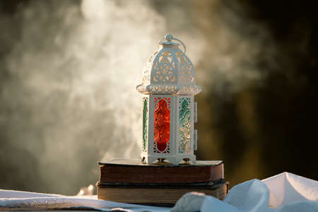 Ramadan Kareem background. Ornamental Arabic lantern glowing at night and the Quaran.