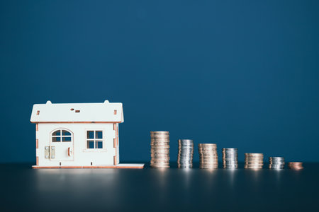 Real estate agent hand holding key near a pile of coins and . Realtor, mortgage, your house, home loan concept. Copy spaceの写真素材
