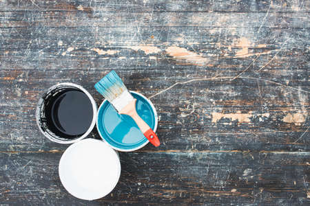 House renovation concept.Paint cans and brush on the old wooden background with copy spaceの写真素材