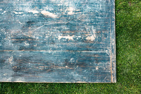 A wooden board on green grass. Template for picnic related design, summertime background with copy...