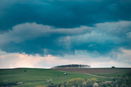 Spring landscape with green hills and stormy skyの写真素材