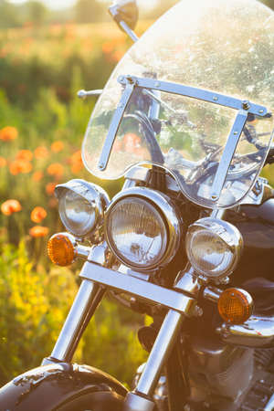 Motorcycle closeup in magic sunset in the poppy field. Travel and sport, speed and freedom conceptの写真素材