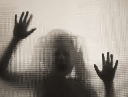 Horror ghost girl behind the matte glass in black and white. Halloween festival concept.の写真素材