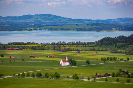 View of the Bavarian 17th century baroque Roman Catholic church St. Coloman and the Forggensee lake...