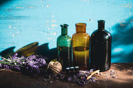 Glass bottle of Lavender essential oil with fresh lavender flowers on wooden rustic table. Aromatherapy, spa, massage concept.の写真素材