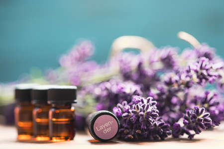 Glass bottle of Lavender essential oil with fresh lavender flowers wooden rustic table. Aromatherapy, spa, massage concept.の写真素材