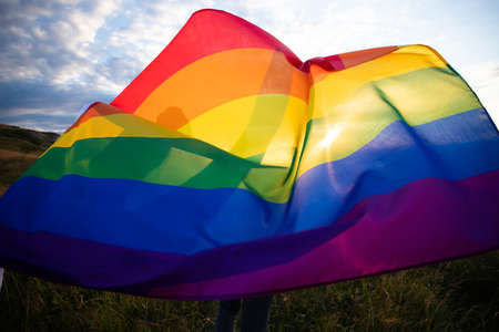 Woman holding a Gay Rainbow Flag.Happiness, freedom and love concept for same sex couplesの写真素材