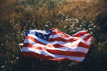 Close up view of USA flag that lying down on summer meadow. 4th of July - Independence day.の写真素材