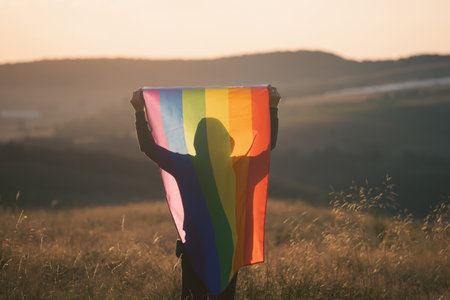 Man holding a Gay Rainbow Flag. Happiness, freedom and love concept for same sex couplesの写真素材