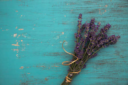 Flat lay of fresh lavender flowers on turquoise wooden background. Aromatherapy, spa, massage concept.の写真素材