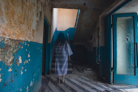 Ghost in abandoned, haunted house. Horror scene of scary spirit of a woman, halloween concept.の写真素材