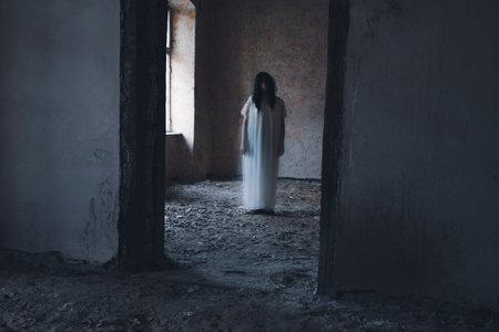 Ghost in abandoned, haunted house. Horror scene of scary spirit of a woman, halloween concept.の写真素材